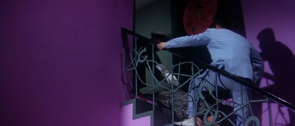 Man fights up the stairs of a purple room