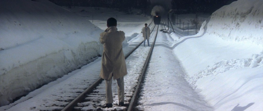 Mexican duel on a snowy train tracks as a train approaches