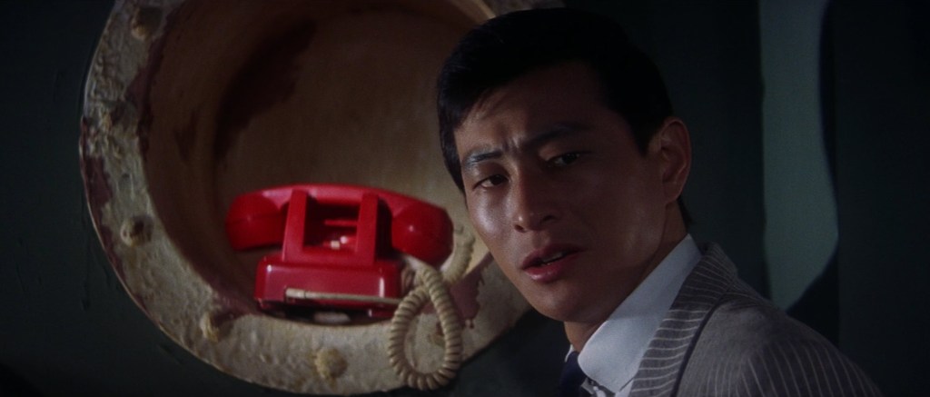 Man looking away from a red phone
